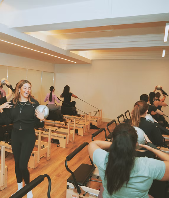 Two members on reformers at Innerform's Lewisham studio, mid-class.